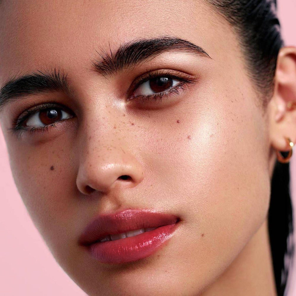 Depuplum applied on lips demonstrating sheer cranberry color and hydrating comfort