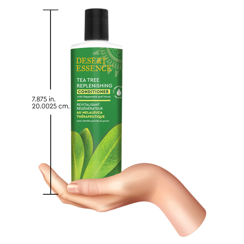 Desert Essence conditioner next to hand to show 12.7 fl oz scale
