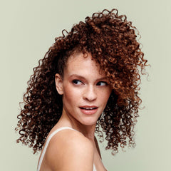 DevaCurl bottle in shower being used to demonstrate easy application and gentle cleansing