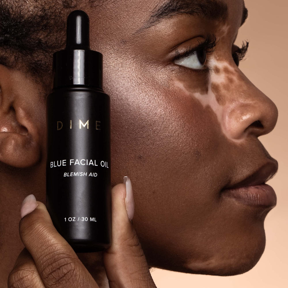 Hand patting DIME oil onto skin to show easy, non-greasy application