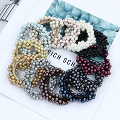 Dizila hair tie beside a quarter illustrating compact size and stretch
