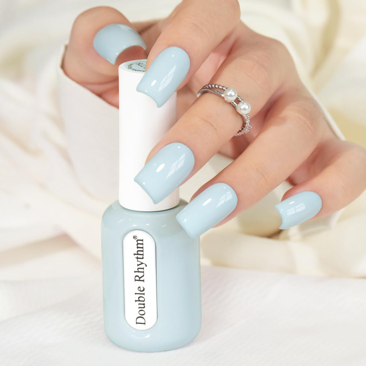 Double Rhythm front bottle creamy blue showing accurate shade and glossy benefit