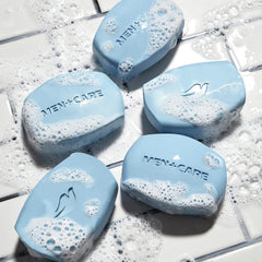 DOVE MEN + CARE bar next to a hand for size comparison showing convenient use benefit