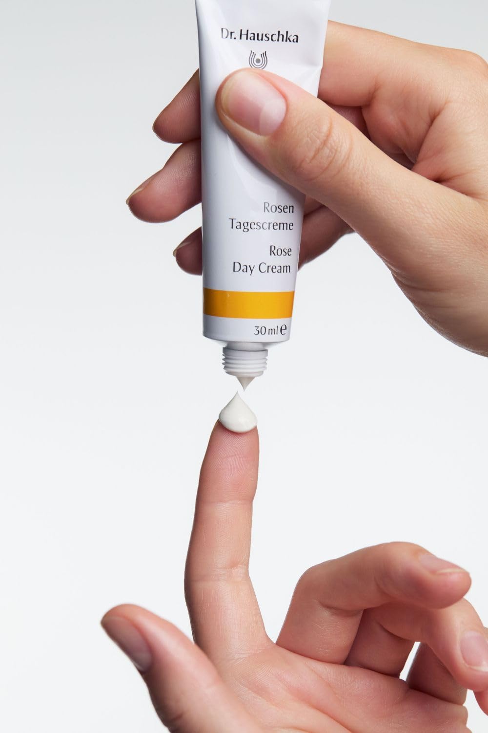 Dr. Hauschka applying cream to face in morning routine for calming effect
