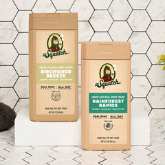 Dr. Squatch two 14 oz bottles beside a hand for scale and practical size