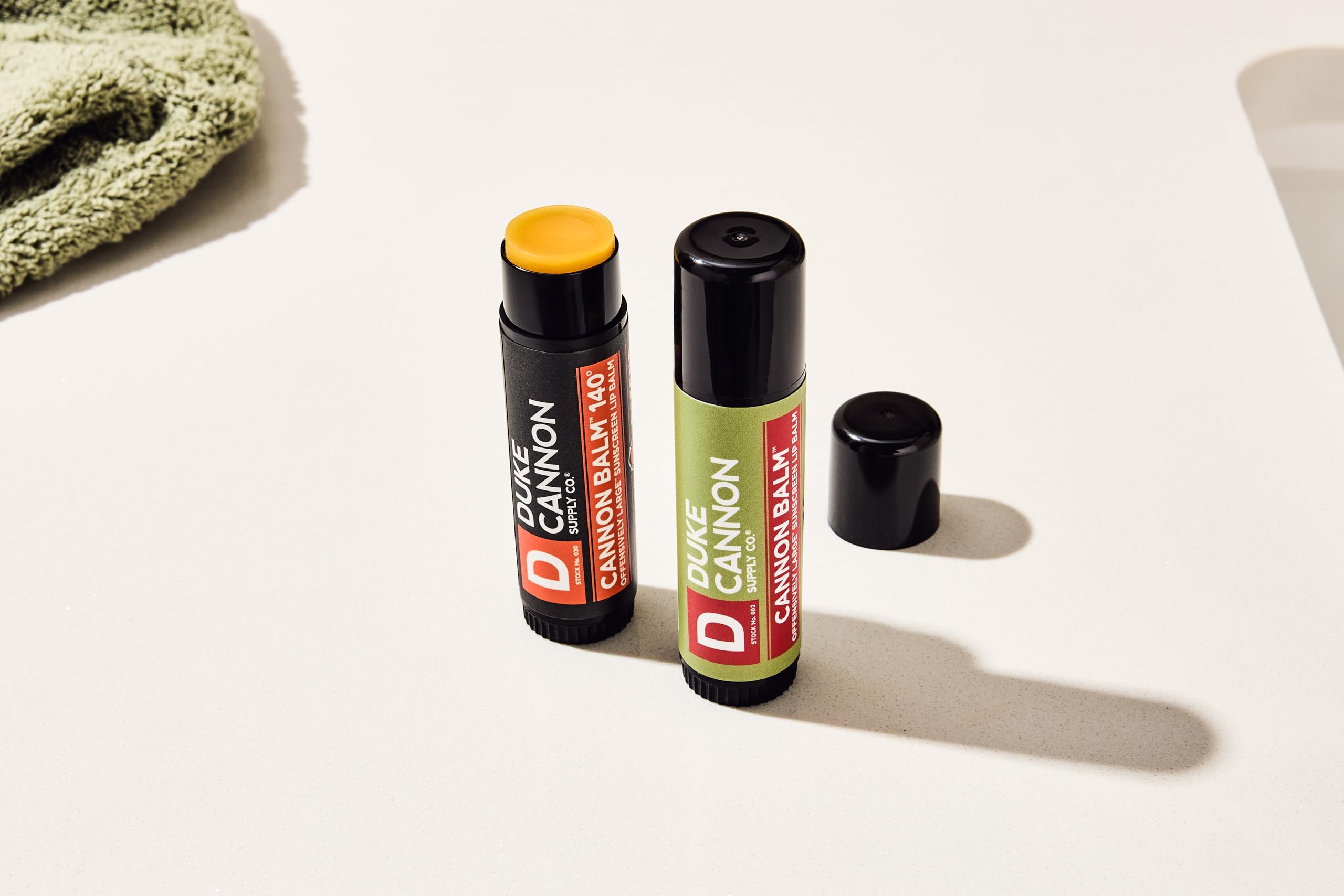 Duke Cannon blood orange balm in use outdoors on lips, provides sun protection during activity