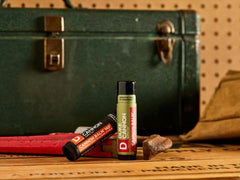 Duke Cannon blood orange open tube texture close-up, thick heat-resistant balm for lasting coverage