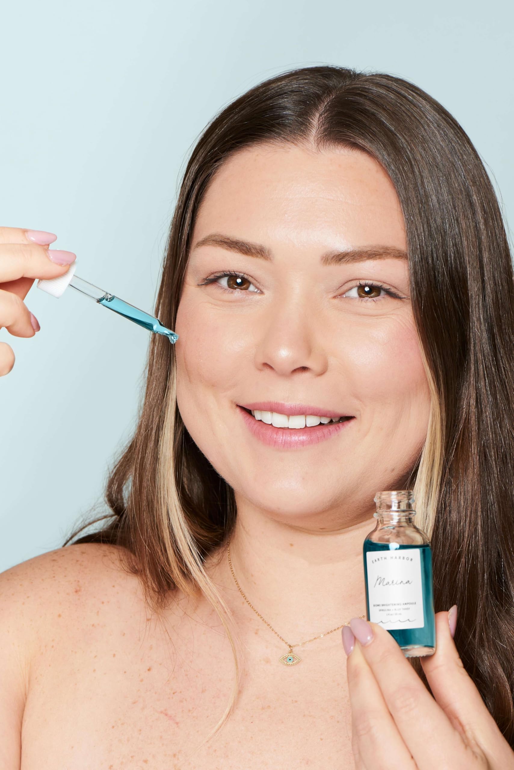 Earth Harbor hand applying MARINA serum demonstrating hydration benefit