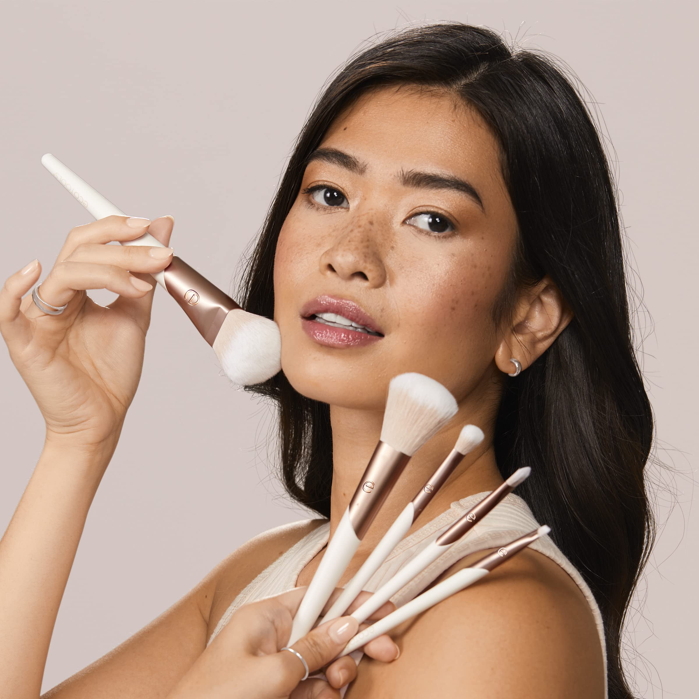 EcoTools tapered blending brush near eyelid for seamless shadow diffusion
