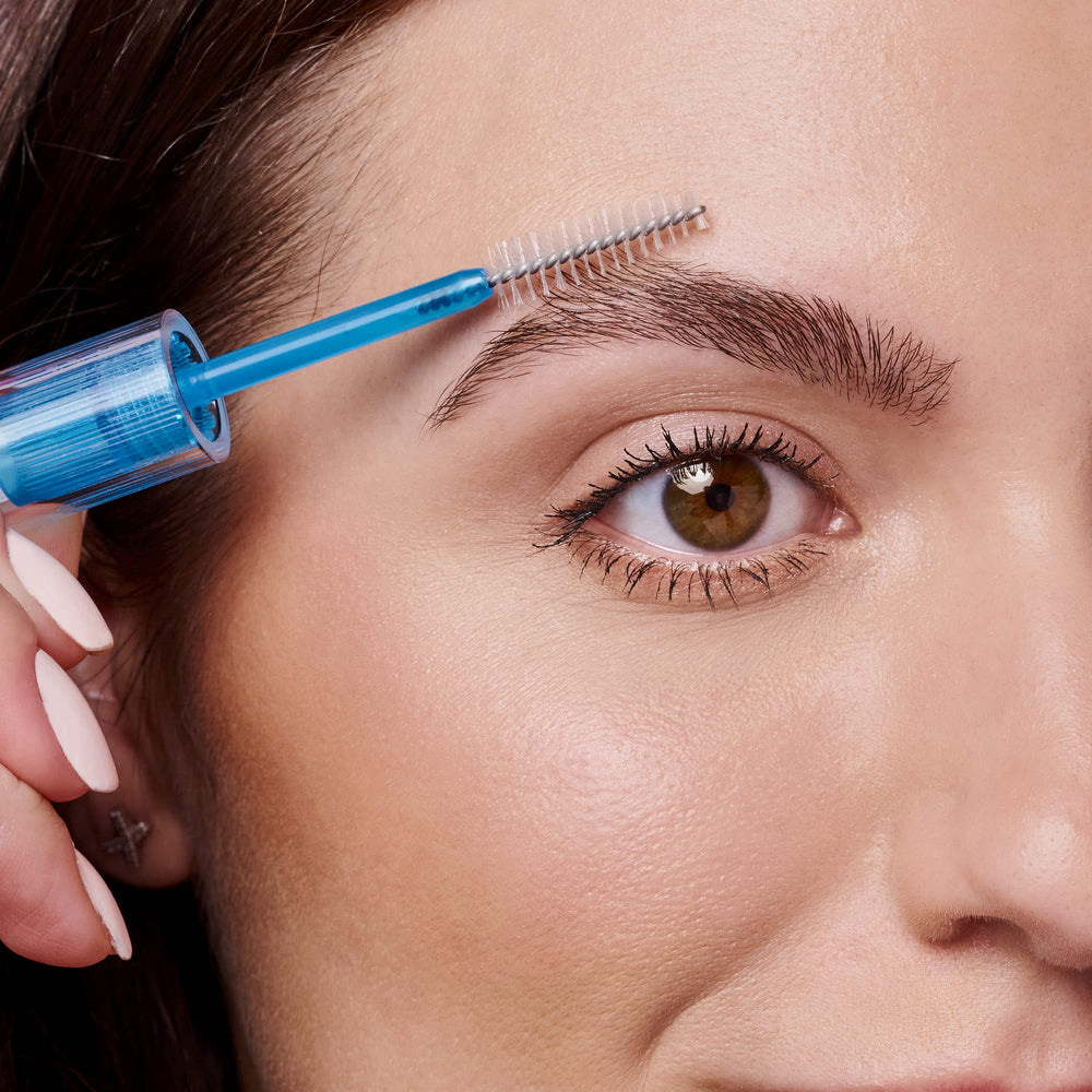 essence applying clear gel to eyebrow for natural hold and polished shape