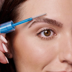 essence applying clear gel to eyebrow for natural hold and polished shape