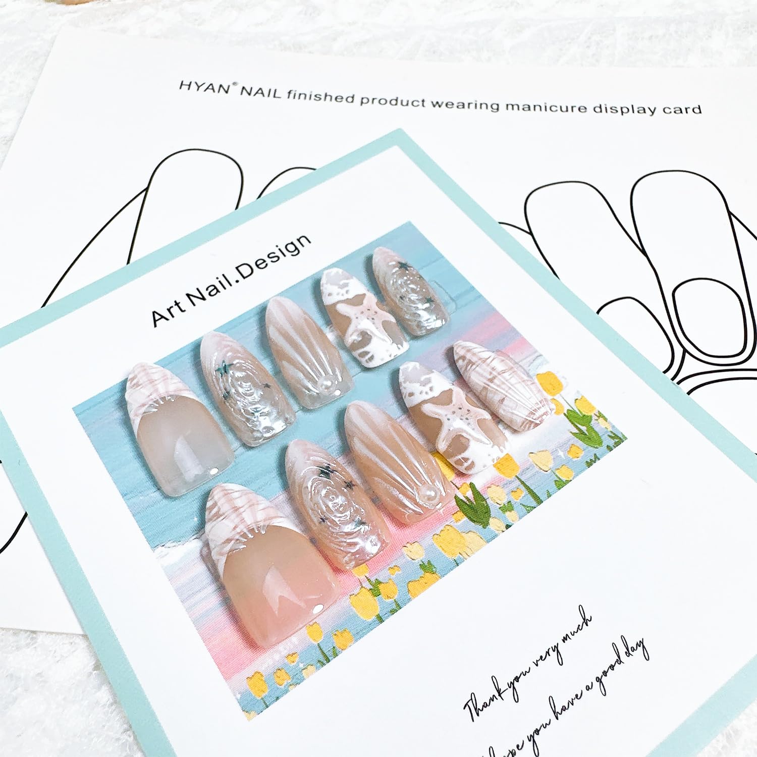 FDSQHSA nails worn on hands in beach setting showcasing finished manicure