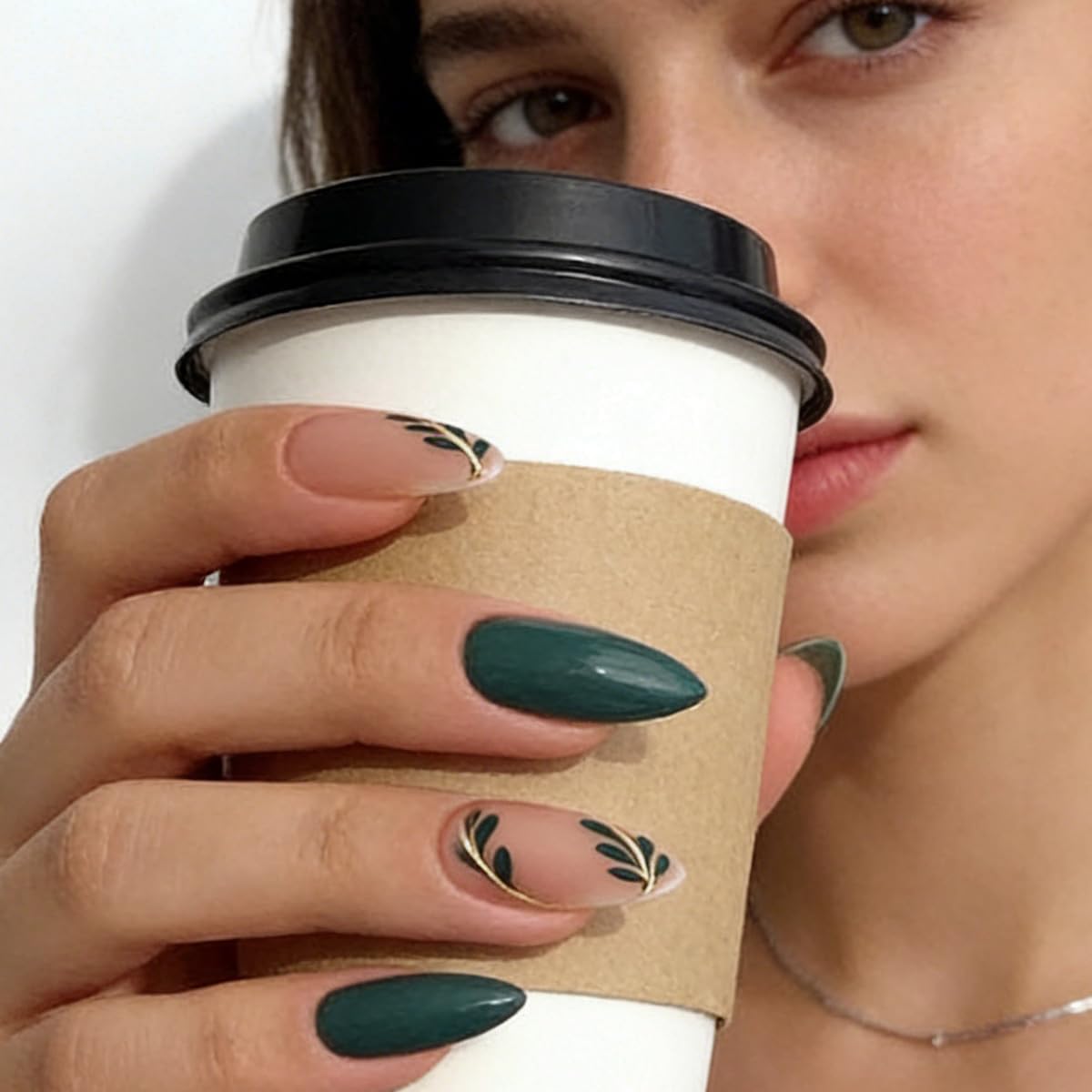 FJSMTOPl close-up of leaf design on an almond nail highlighting decorative detail