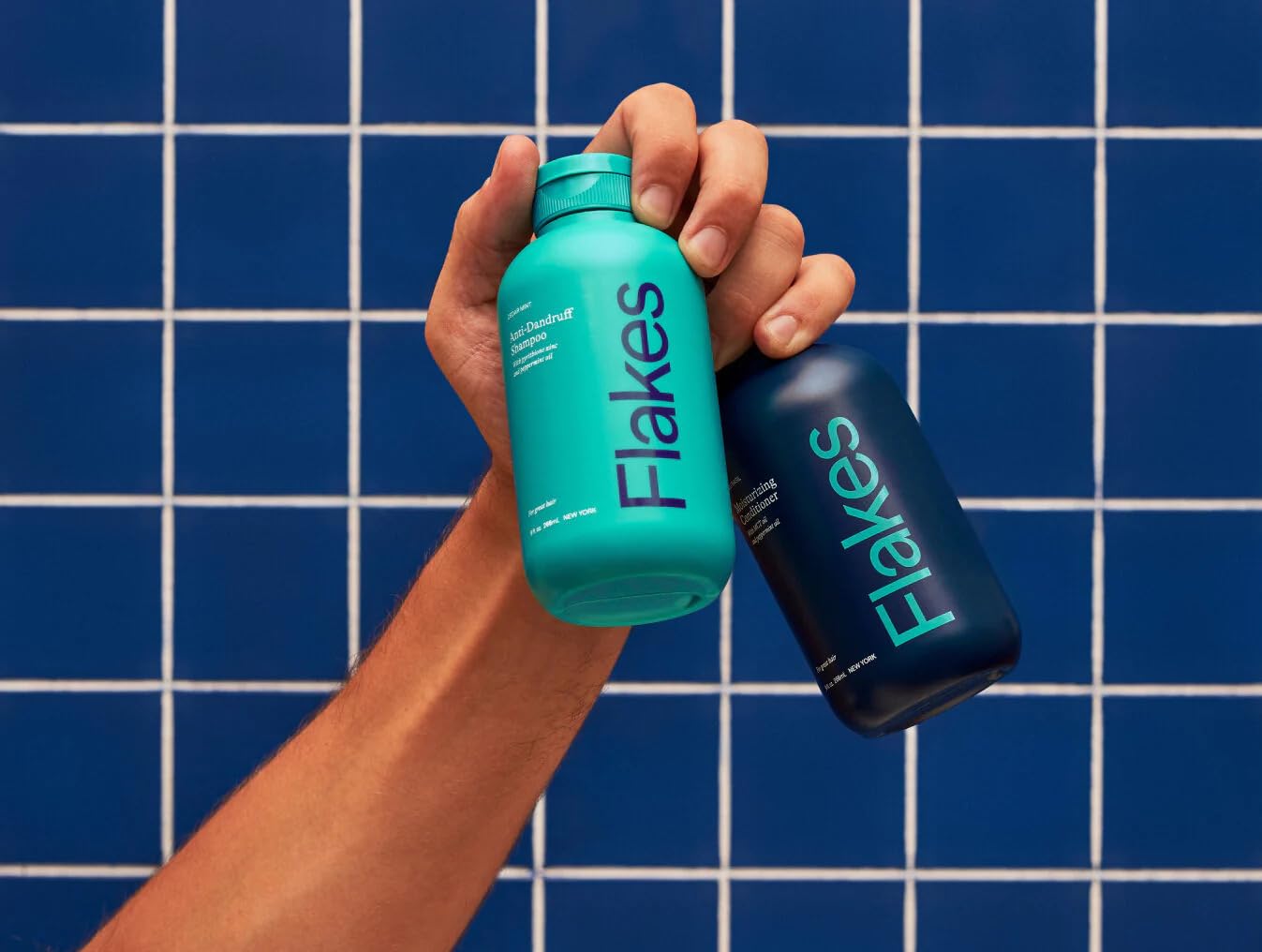 Flakes shampoo and conditioner in shower demonstrating in-use benefit