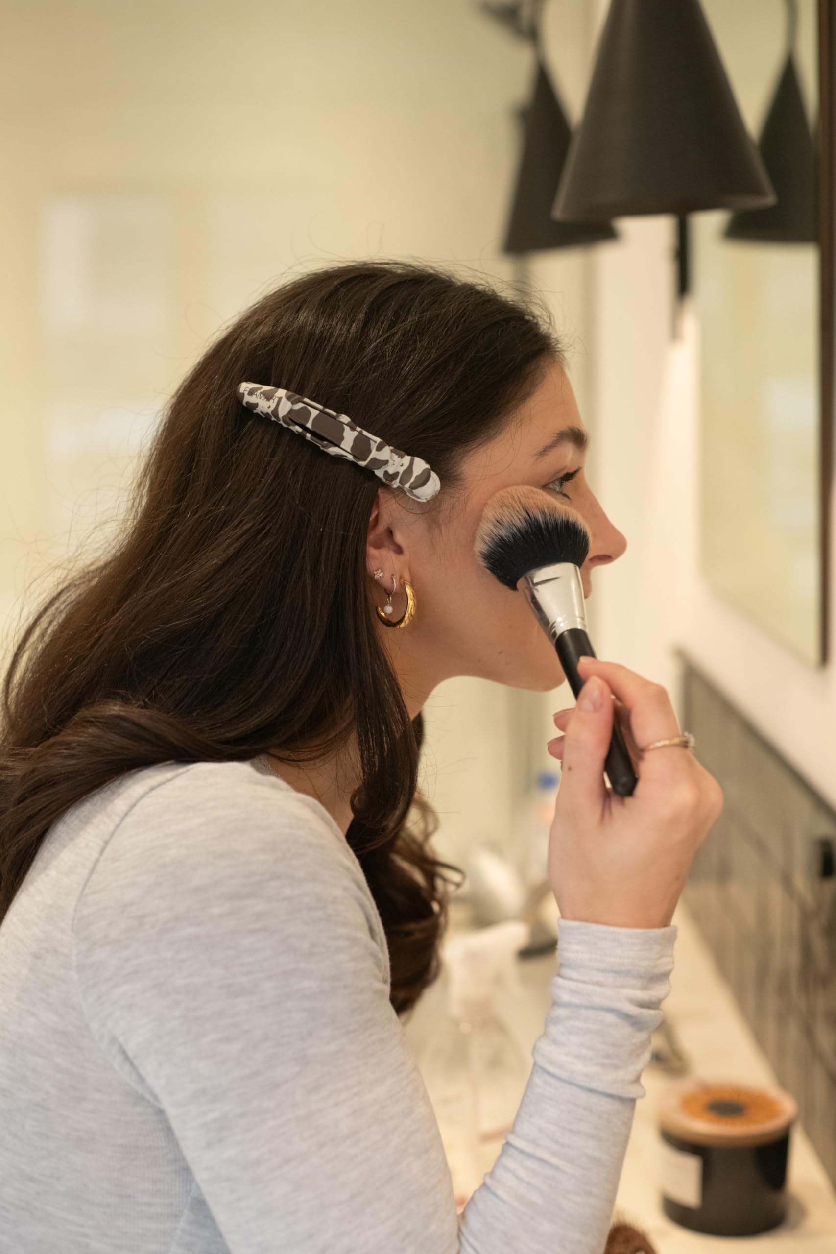 FRAMAR clip held beside a hand showing size and easy handling for stylists