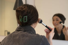 FRAMAR clip beside a handbag showing travel-friendly, stylish accessory