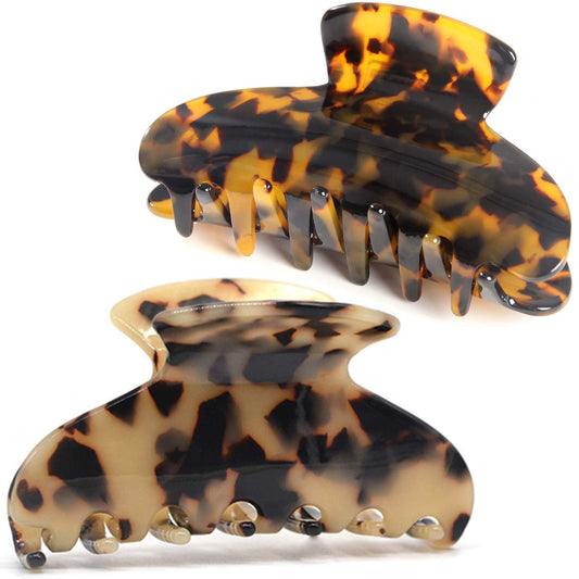 Fsmiling front view of two tortoise claw clips showing pattern and compact shape for styling