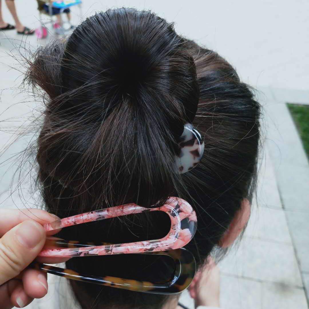 Fsmiling lifestyle shot of woman wearing an updo showing elegant accessory