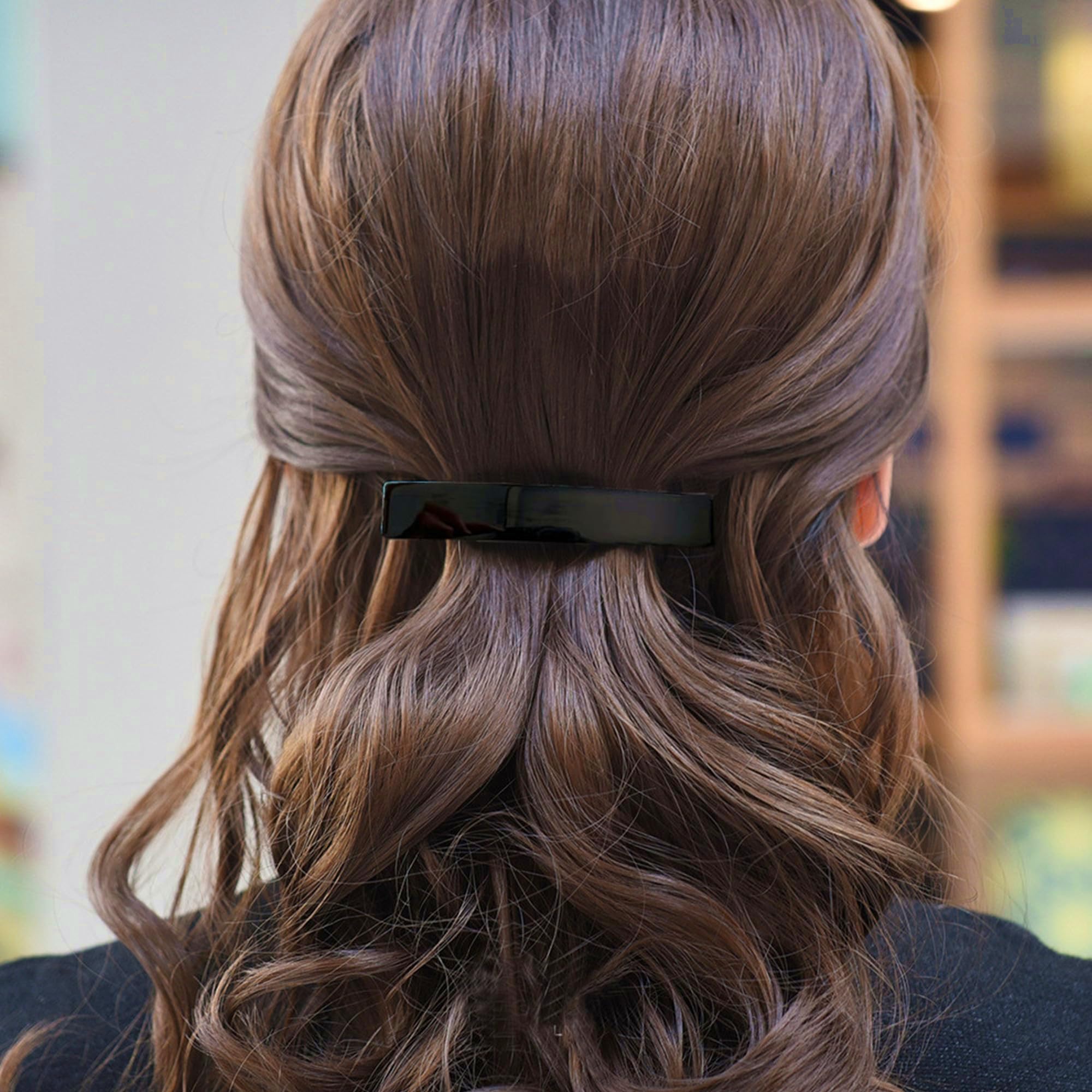 Fsmiling side profile of barrette on bun, shows low-profile finish and comfort