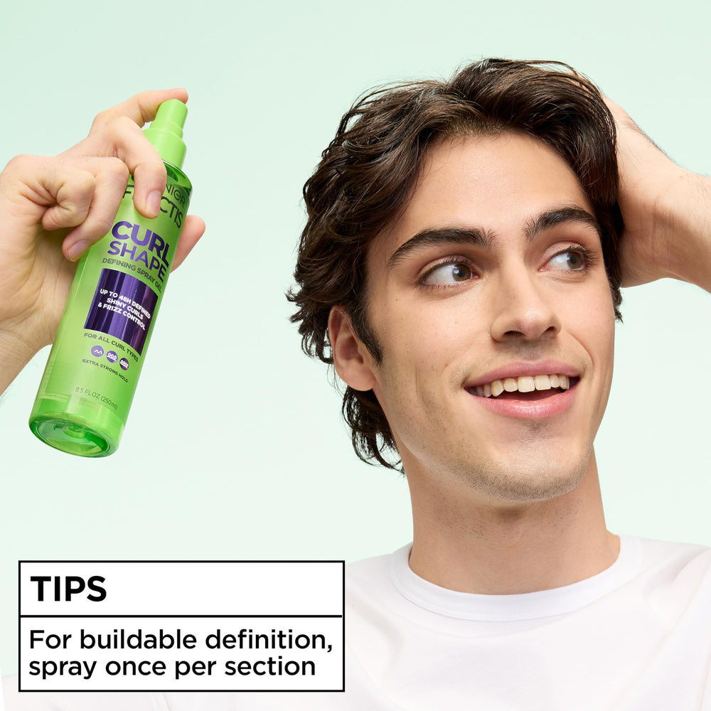garnier model applying spray to curly hair demonstrating frizz control
