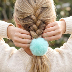 Gegraterwa pom pom worn in a ponytail adding a playful accent