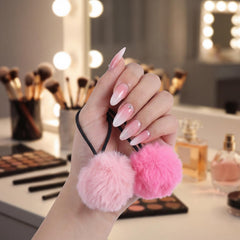Gegraterwa pom pom next to a hand showing accurate 2-inch size