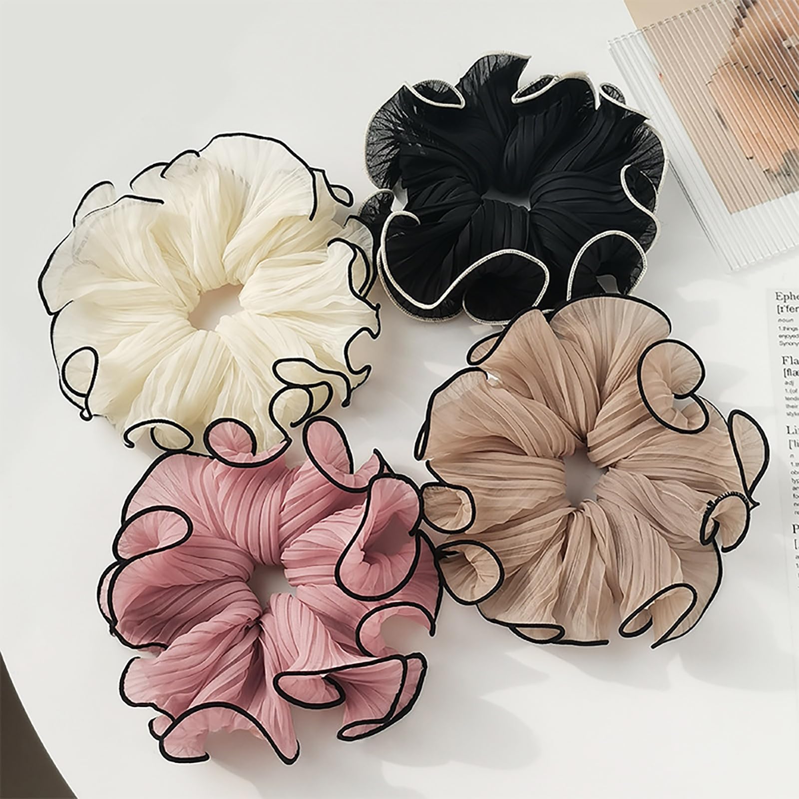 Generic scrunchies next to hand for size comparison, demonstrates roomy fit for thick hair
