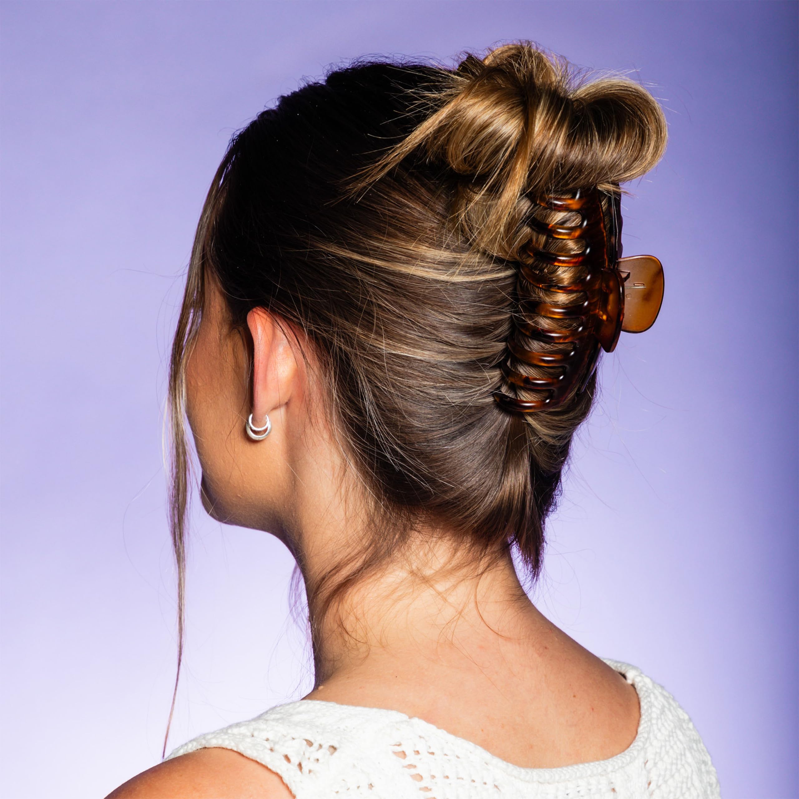 GIMME clip holding a high bun to secure voluminous curly hair