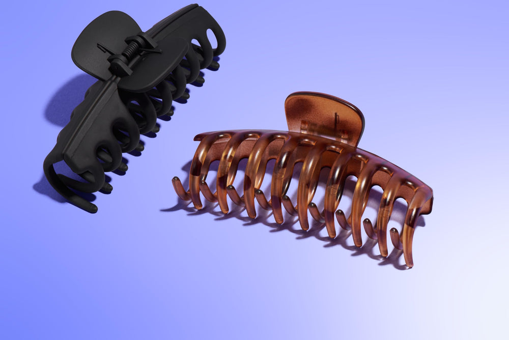 GIMME clip beside hand showing size and comfortable, lightweight feel