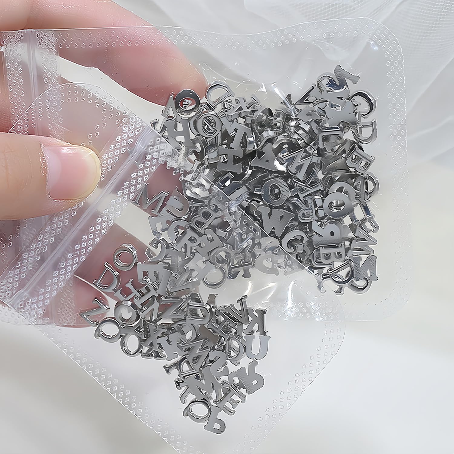 GJJBQTT close-up of polished alloy letters, highlights smooth reflective finish