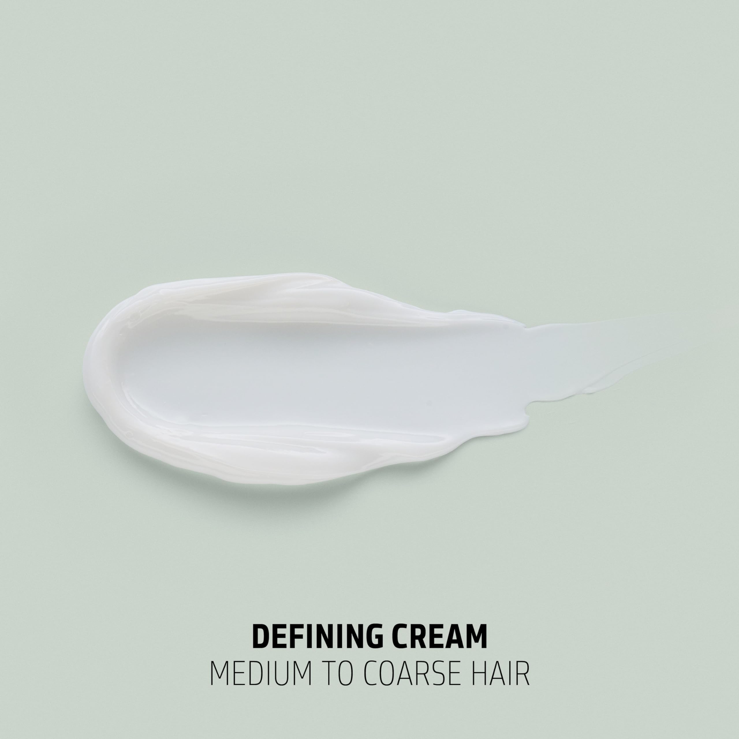 Goldwell cream in hand close-up showing creamy texture and moisture for defined curls