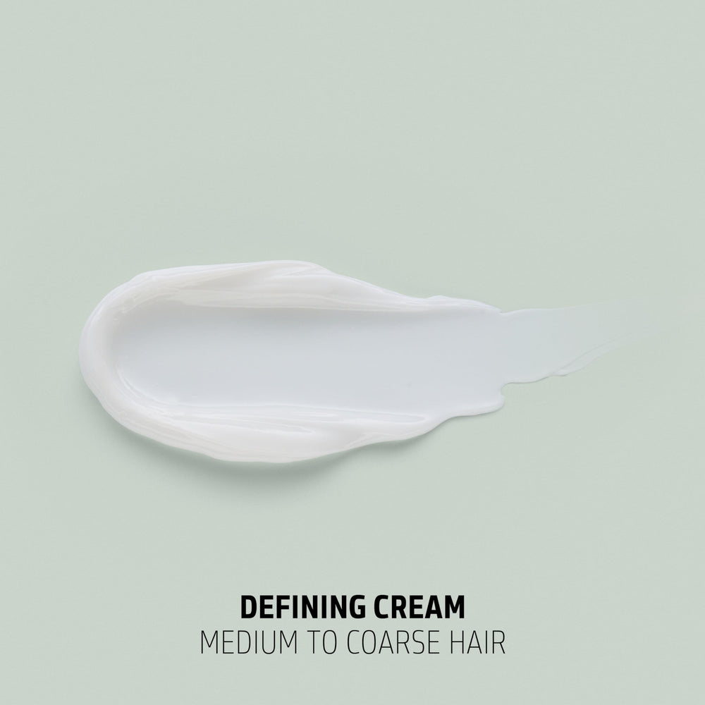 Goldwell cream in hand close-up showing creamy texture and moisture for defined curls