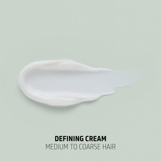 Goldwell cream in hand close-up showing creamy texture and moisture for defined curls