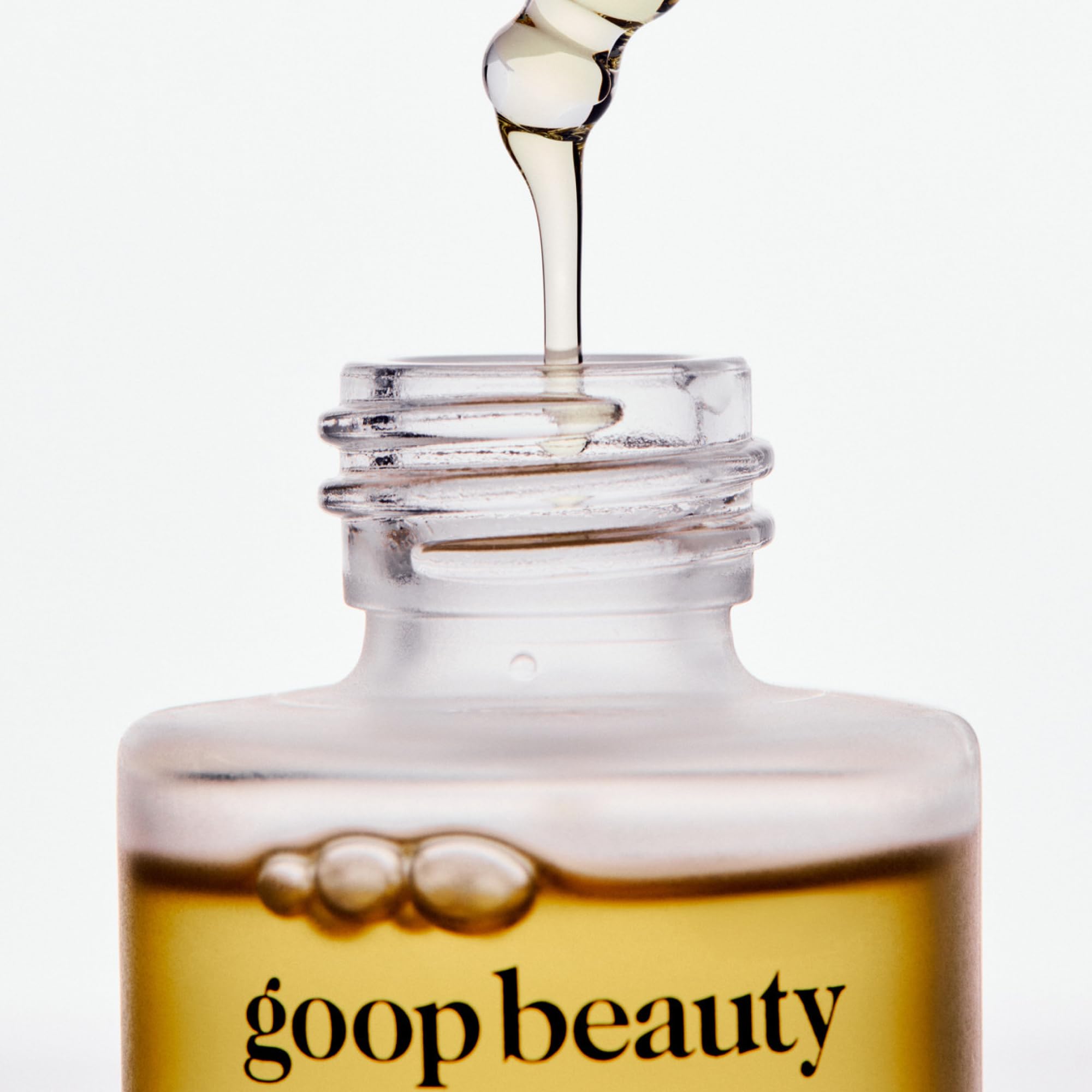 goop nutrient face oil bottle scale with hand illustrating compact one‑ounce size