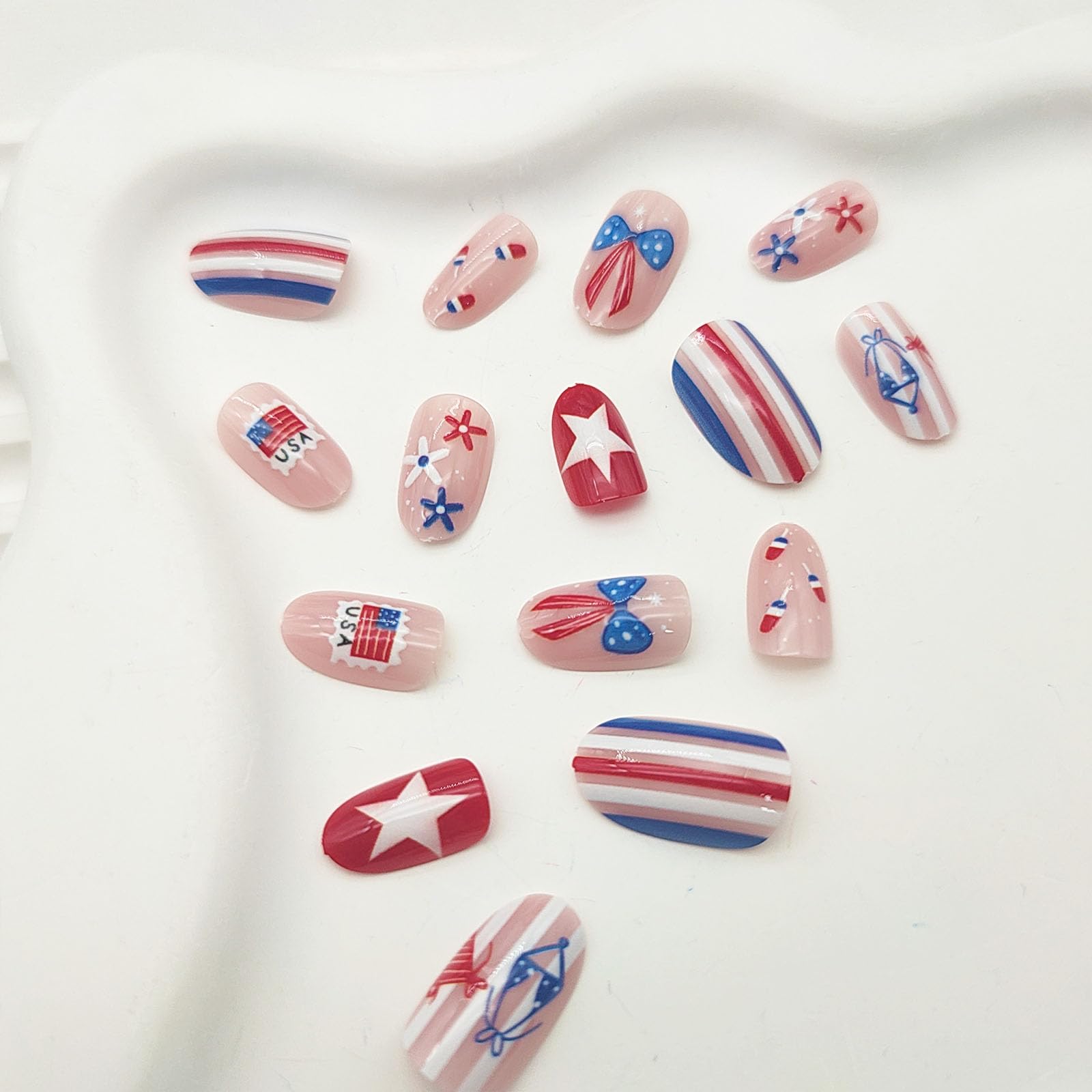GXOIPNS nails worn on hand in patriotic setting, demonstrating festive short almond-oval fit
