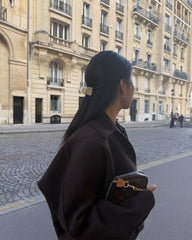 Hana Mia securing a small ponytail to demonstrate secure hold for layered hair benefit