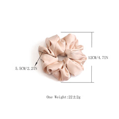 Helamvly scrunchie beside a hand for scale showing jumbo size and generous elastic