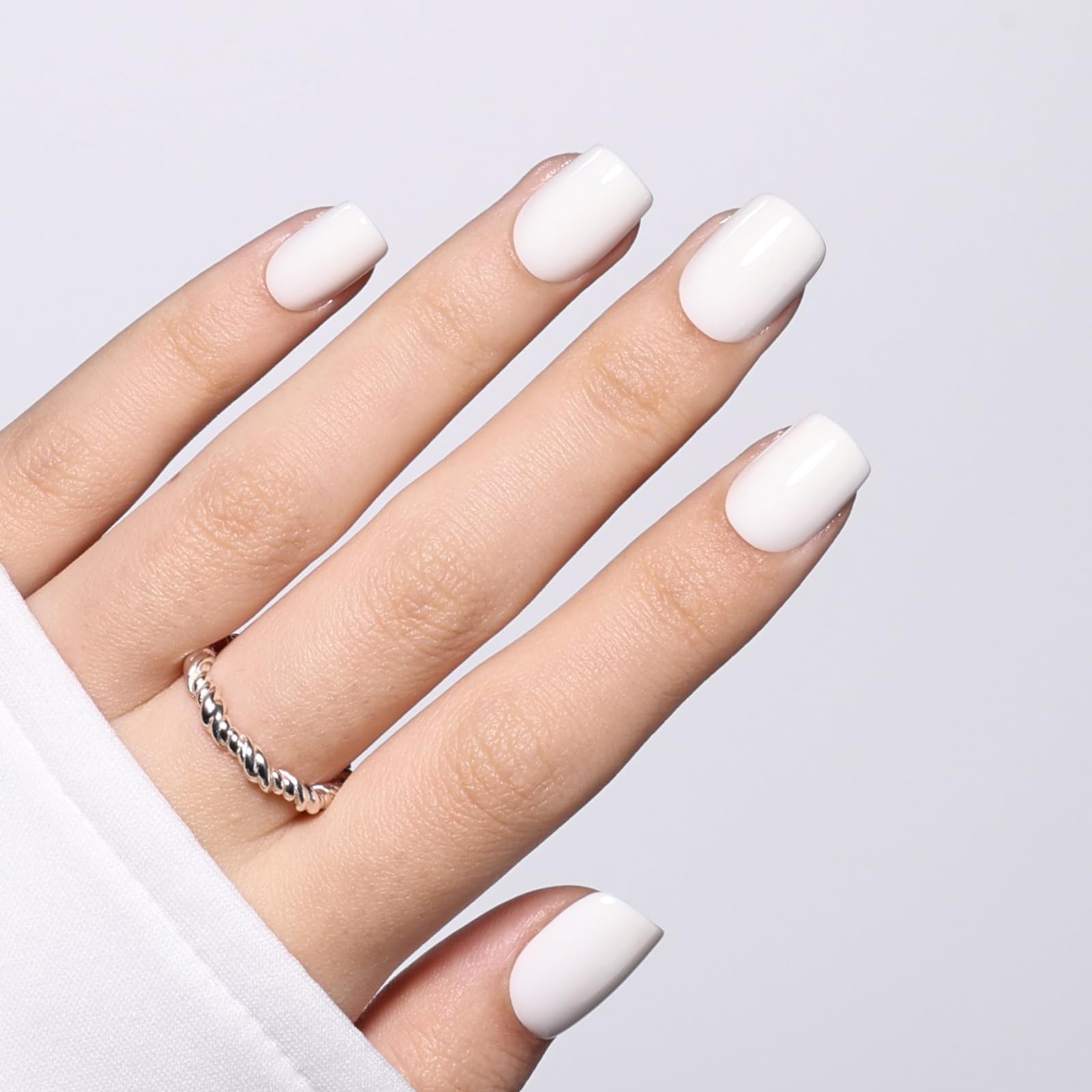 Herlight lifestyle photo of hands wearing white nails paired with casual outfit