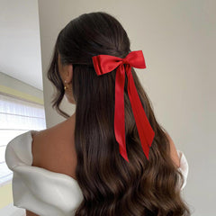 hisial bow placed on a low ponytail adding shine and refined finish benefit: instant polish