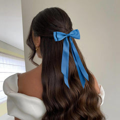 hisial bow clipped in a half-up hairstyle adding polished, feminine finish