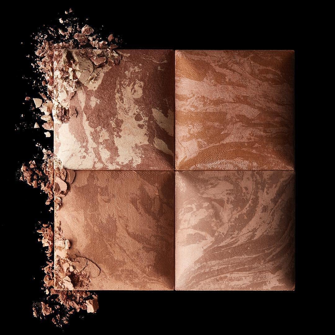 Brush picking up Hourglass bronzer demonstrating easy application and buildable color