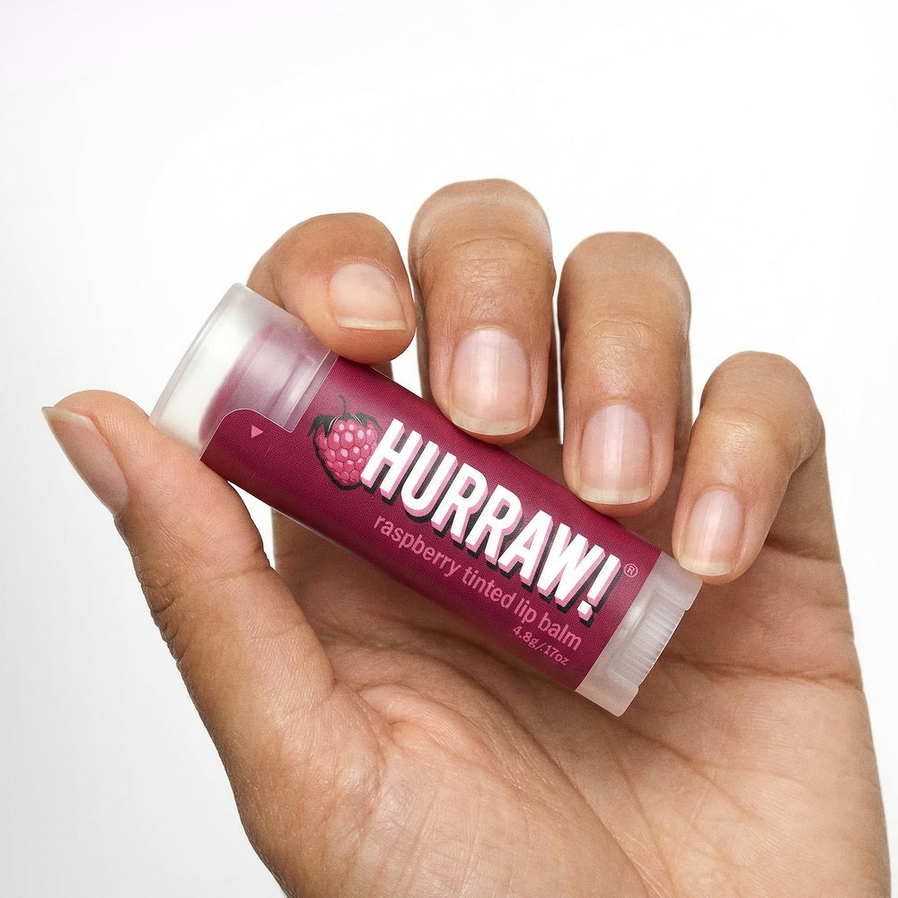 Hurraw! lifestyle outdoors shot applying balm for natural tint and hydration