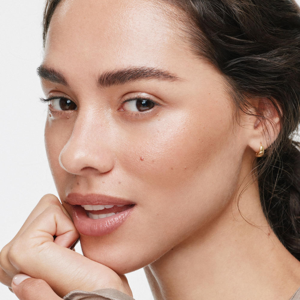 ILIA multi-stick blended on cheek detail showing natural luminous bronze and seamless blend