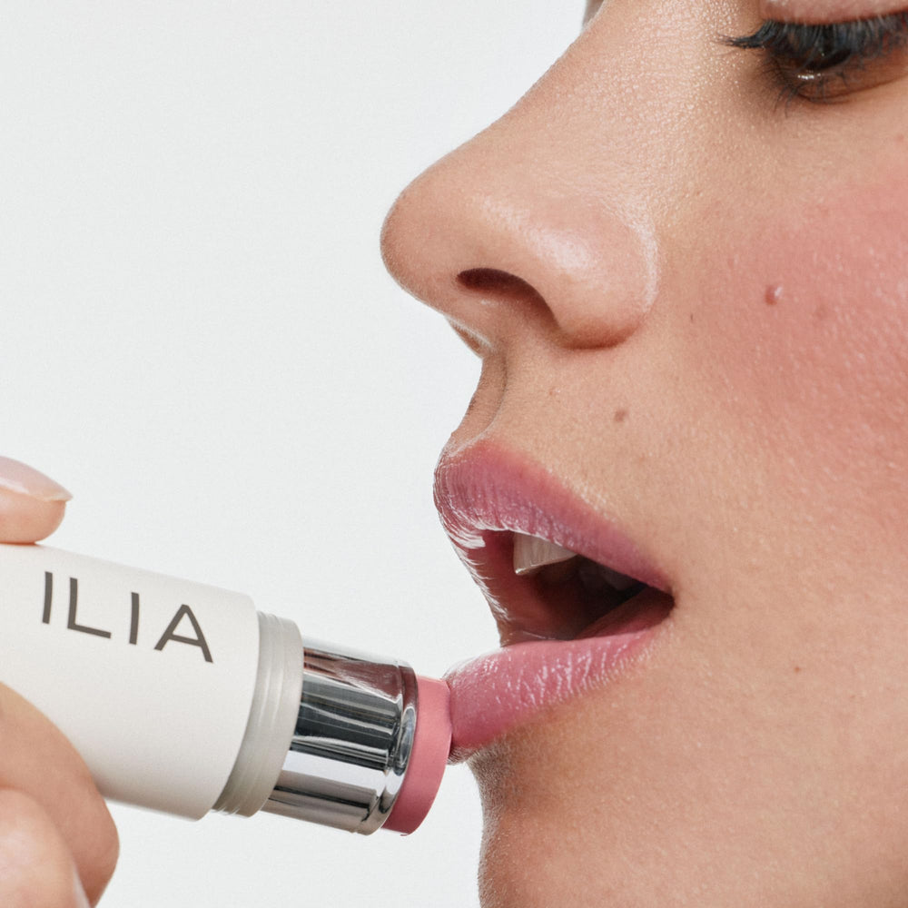 ILIA applying multi‑stick to cheek in lifestyle scene for quick touchups