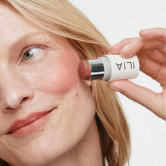 ILIA multi-stick being applied to lips showing natural tint and nourishing finish