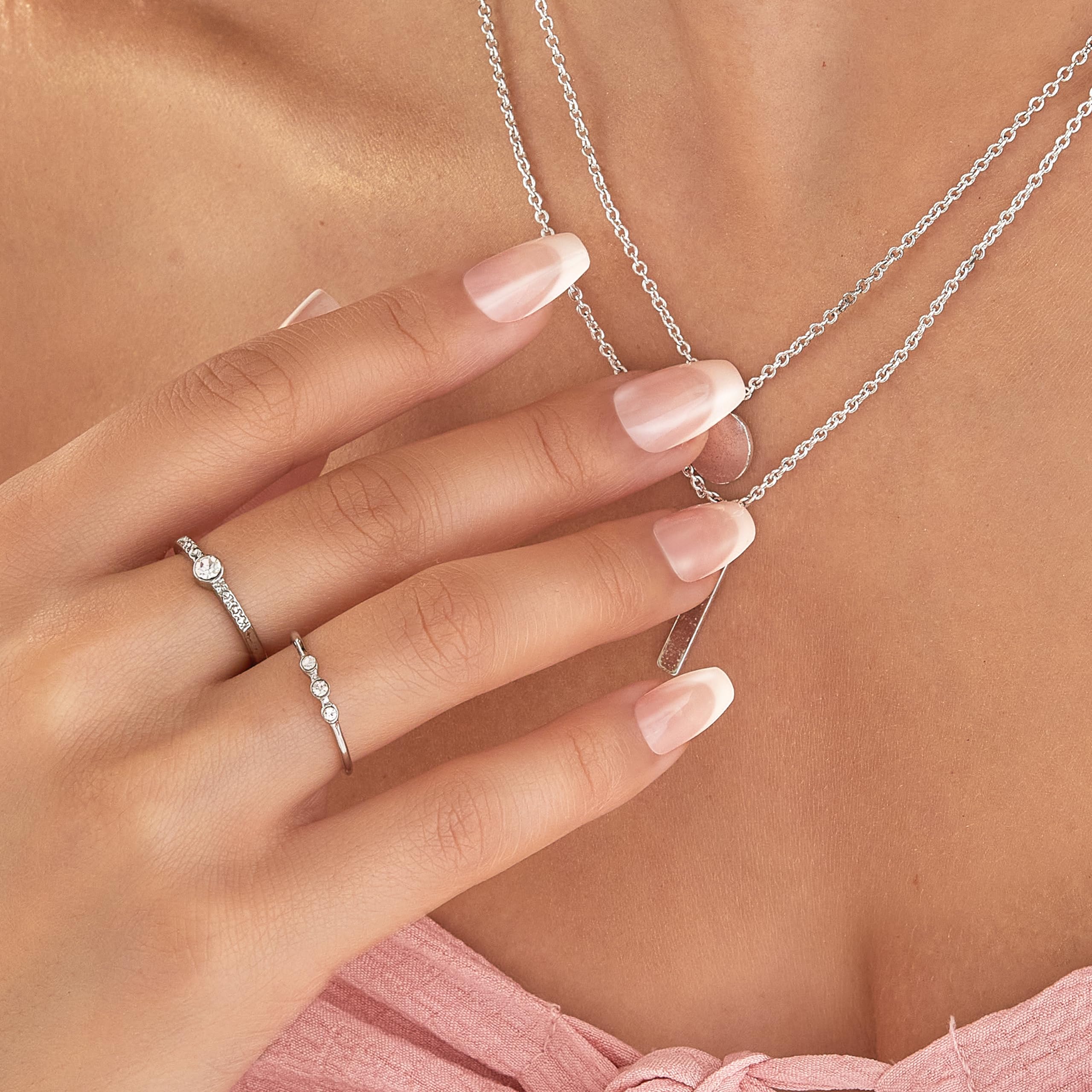 imPRESS nails on fingers beside coin for scale demonstrating medium coffin length