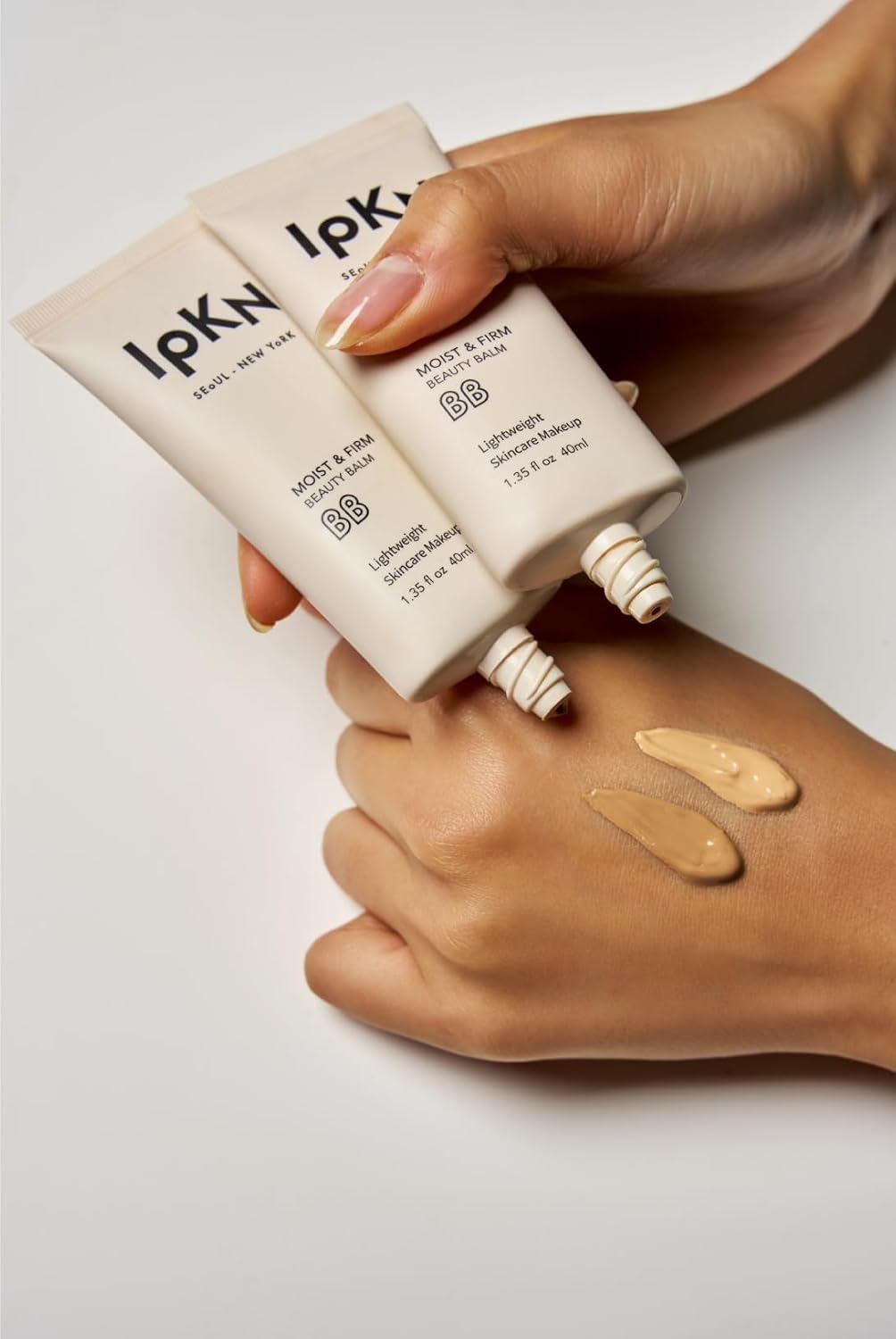 IPKN BB Cream next to coin to show compact size and travel convenience