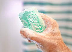 Irish Spring bar in shower with water demonstrating quick rinsing benefit