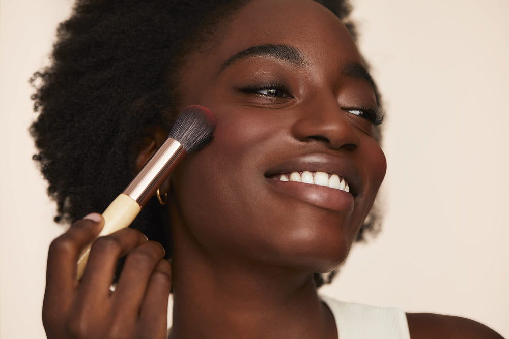 jane iredale brush applying blush to cheek for seamless finish benefit: effortless blending