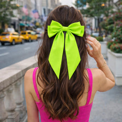 JazSwirl bow next to hand for scale showing true oversized statement benefit